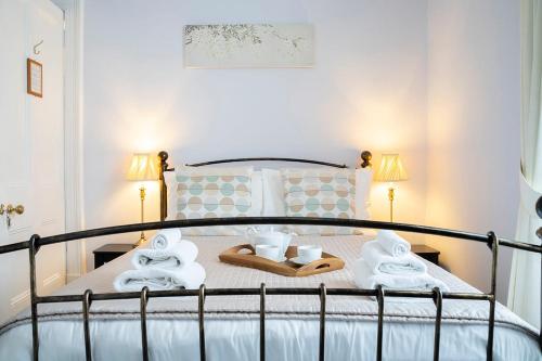 a bedroom with a bed with towels and slippers at Queensberry House B&B in Moffat