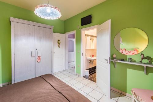een badkamer met groene muren, een wastafel en een spiegel bij B&B Cinque Stelle Salento in Marina di Mancaversa