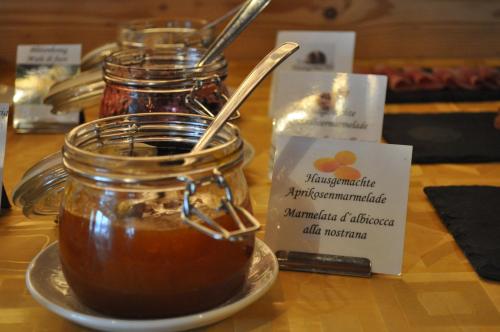 a jar of honey with a spoon on a table at Boutique Pension Erlacher - Adults Only in Villandro