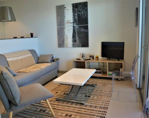 a living room with a couch and a tv at TADO in Kamiesch
