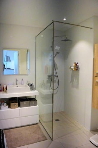 une salle de bain avec une douche en verre et un lavabo dans l'établissement TADO, à Kamiesch