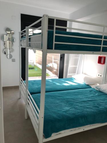 a bedroom with a bunk bed with blue sheets at Vistabella Golf Bali 11 in Vistabella