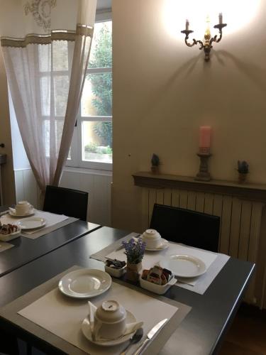 a dining room table with plates of food on it at Hotel du Centre in Pierrelatte
