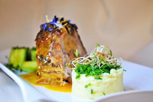a plate of food with a piece of meat and rice at Boutique Pension Erlacher - Adults Only in Villandro