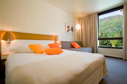 a hotel room with a bed and a large window at Novotel Grenoble Nord Voreppe in Voreppe