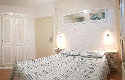 a white bedroom with a bed with two pillows at B&B Casa Derosas in Golfo Aranci