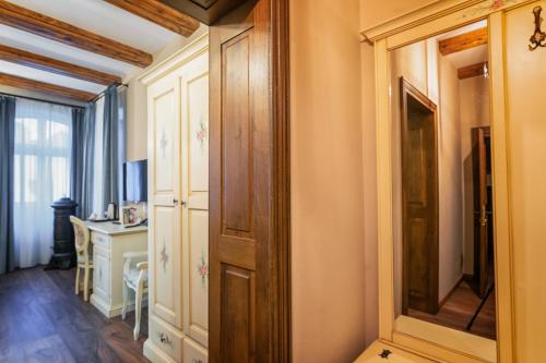 a hallway with a mirror and a desk in a room at HOTEL BOUTIQUE CASA CHITIC -HOTEL AND RESTAURANT Str Johann Gott nr7 in Braşov