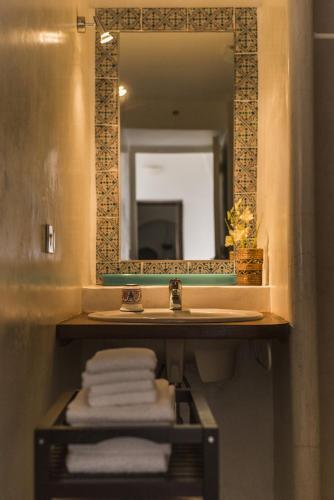 a bathroom with a sink and a mirror and towels at Dammuso Sant'Anna in Pantelleria