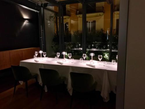 a long white table with wine glasses on it at Bacã Suites, Restaurant & Bar in Taranto