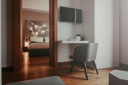 a bedroom with a mirror and a bed and a chair at Bacã Suites, Restaurant & Bar in Taranto
