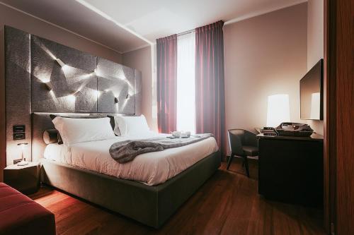 a hotel room with a bed and a desk and a bed sidx sidx sidx sidx at Bacã Suites, Restaurant & Bar in Taranto
