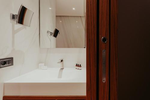 a bathroom with a white sink and a mirror at Bacã Suites, Restaurant & Bar in Taranto