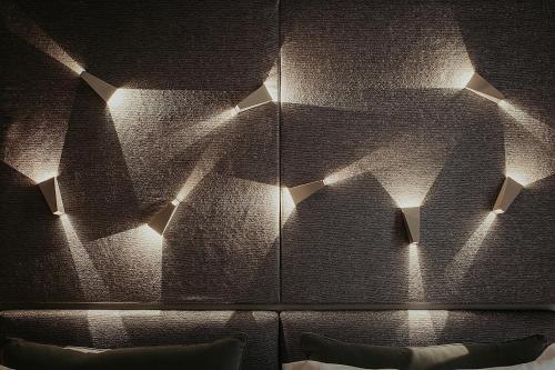 a room with a wall with lights on it at Bacã Suites, Restaurant & Bar in Taranto
