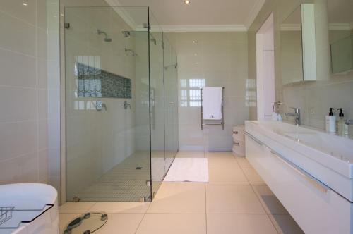 a bathroom with a glass shower and a toilet at Naledi@53 Private Game Farm in Brits