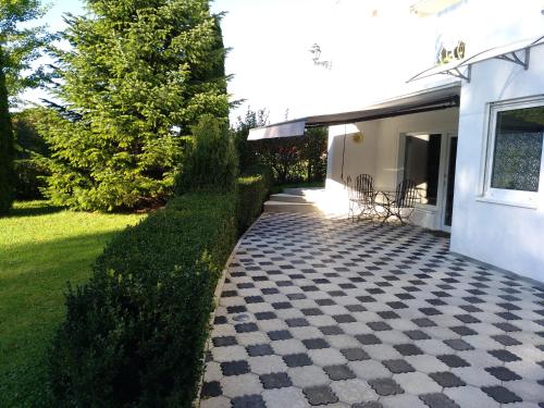 une terrasse avec un sol en damier en face d'une maison dans l'établissement Ferienapartment Tuntenhausen, à Tuntenhausen