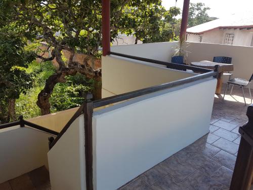 a white fence on a patio with a tree at Pousada Betta in Pirenópolis