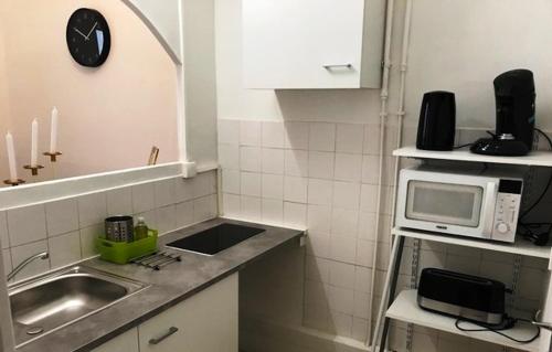 eine kleine Küche mit einer Spüle und einer Mikrowelle in der Unterkunft 38 Rue Papety in Marseille