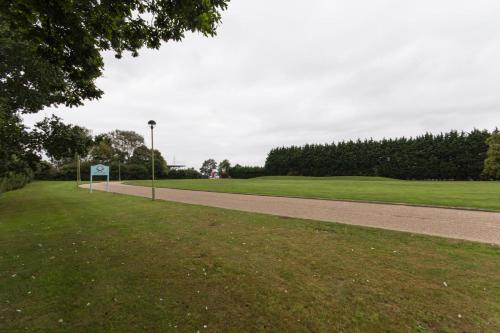 a road next to a green field with a street light at Dragonfly Hotel King's Lynn in Kings Lynn