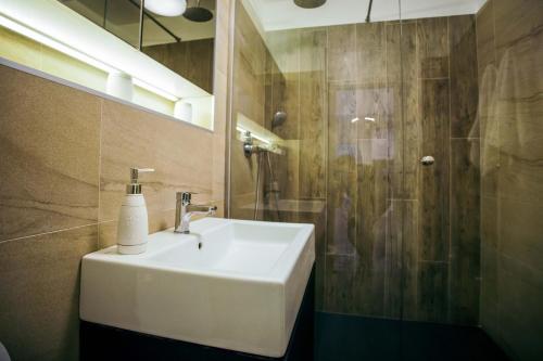 a bathroom with a white sink and a shower at Briana Luxury Apartment in Cluj-Napoca