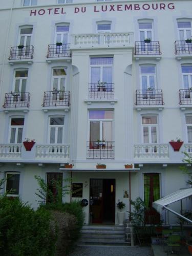 un bâtiment blanc avec balcon et un hôtel durlezlez dans l'établissement Hotel Luxembourg, à Lourdes