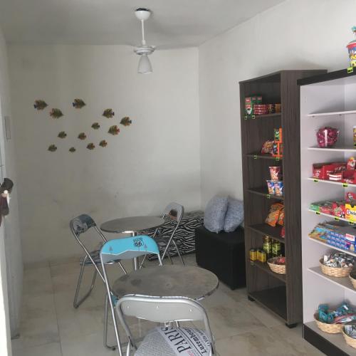 a room with a table and chairs and a shelf at Pousada Bertioga in Bertioga