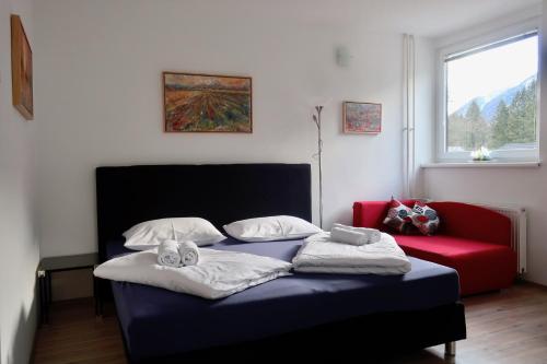 ein Schlafzimmer mit einem blauen Bett und einem roten Sofa in der Unterkunft Apartment Maya in Kranjska Gora