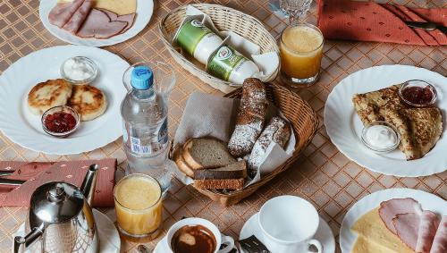 a table with plates of breakfast foods and drinks at Kremlyovsky Hotel in Suzdal