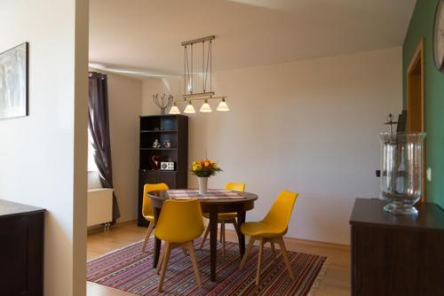 ein Esszimmer mit einem Tisch und gelben Stühlen in der Unterkunft Apartement 1 Große Brüdergasse in Bautzen