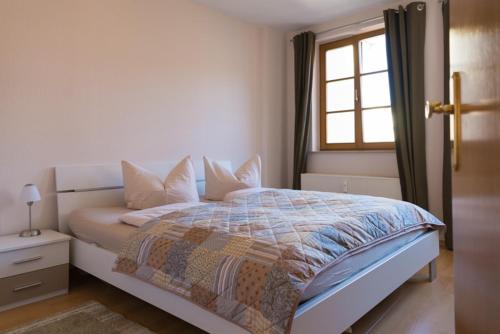 a white bedroom with a bed with a window at Apartement 1 Große Brüdergasse in Bautzen