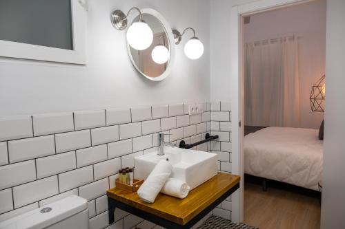 een badkamer met een wastafel en een spiegel bij GOMEZ ROOMS in Xàtiva