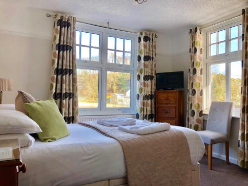 um quarto com 2 camas e uma grande janela em Meadowcroft Guest House em Windermere