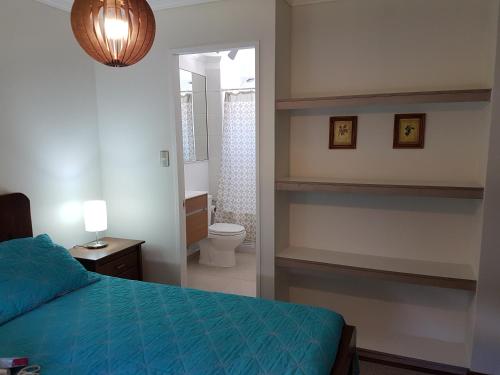 Un dormitorio con una cama y un baño con inodoro. en Casa Robles Pucon, en Pucón