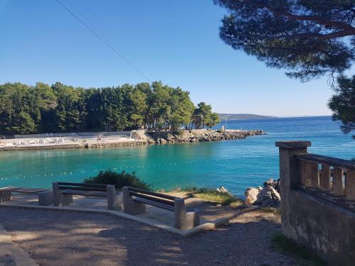a bench sitting next to a body of water at Apartman"Petra" in Krk