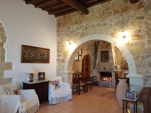 a living room with a stone wall and a fireplace at Wood & Stone in Kissamos