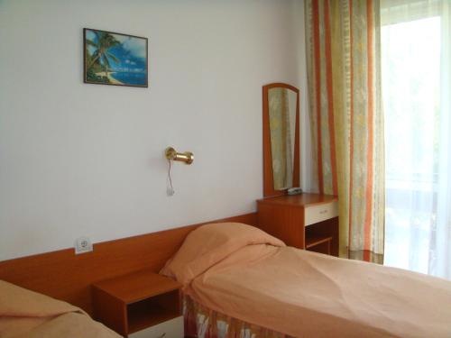 a hotel room with a bed and a mirror at Velingrad Balneohotel in Velingrad