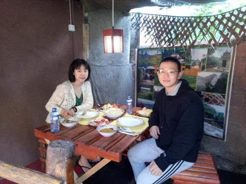 a man and woman sitting at a table with food at Homeaway Homestay Hatton in Hatton