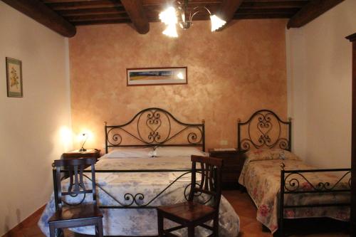 a bedroom with two beds and two tables in it at Agriturismo Il Capannone in Montemerano
