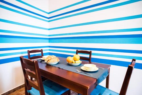 een eettafel met een blauwe en witte gestreepte muur bij Indigo Apartment With Free Parking in Boedapest