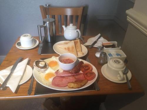 a table with a plate of breakfast food on it at Kinder Lodge in Hayfield