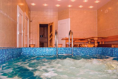 a bath tub with a pool of water in a room at Mozart Hotel in Khabarovsk