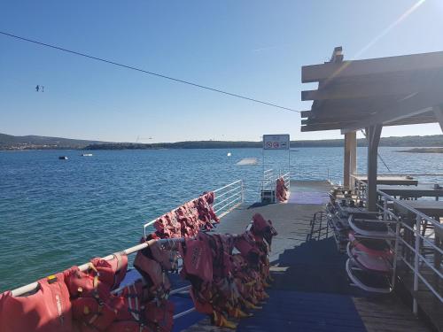 a pier with chairs and towels on the side of the water at Apartman"Petra" in Krk
