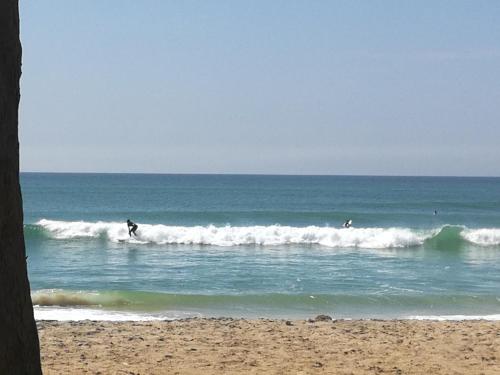 a group of people riding waves in the ocean at Chez medzo et patou in Poponguine