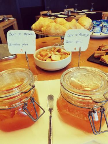 a table with jars of honey and a bowl of fruit at Quinta De Casaldronho Wine Hotel in Lamego
