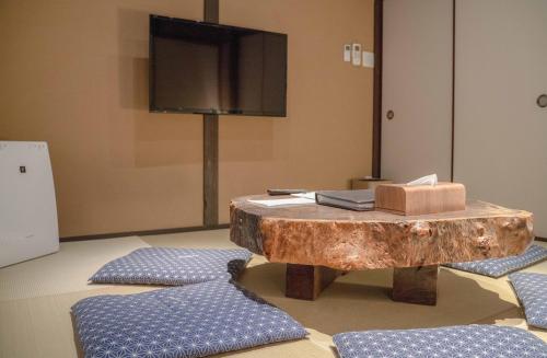 a living room with a wooden table and a tv at Reikaku Kiyomizu Gojo in Kyoto