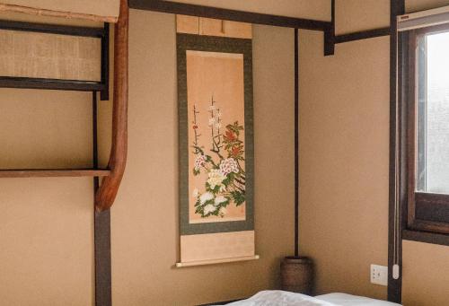 a bedroom with a painting of flowers on the wall at Reikaku Kiyomizu Gojo in Kyoto