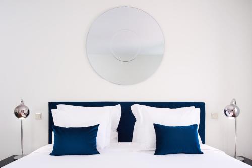 a bedroom with a bed with blue pillows at Convento do Seixo Boutique Hotel & Spa in Fundão