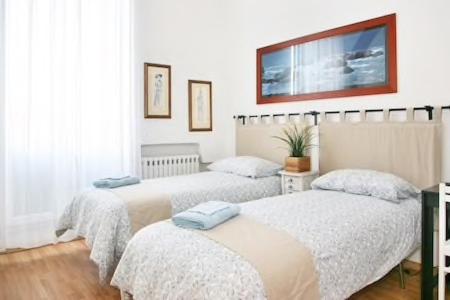 a bedroom with two beds and a tv on the wall at Il Podesta in Florence