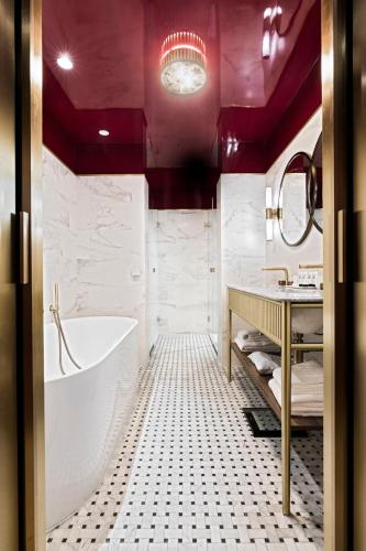 a bathroom with a white tub and a sink at Grand Powers Hotel in Paris