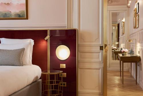 a bedroom with a bed and a lamp next to a door at Grand Powers Hotel in Paris