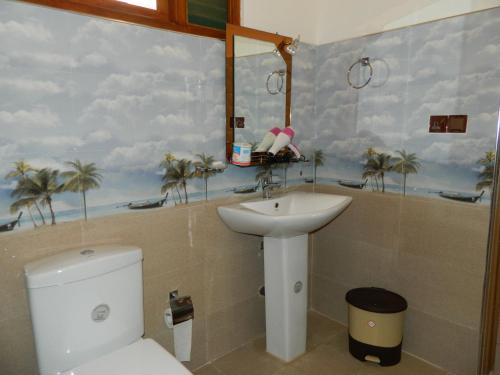 a bathroom with a sink and a toilet and a mirror at sunlit cottage ella in Ella